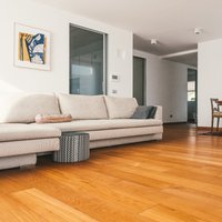 Residenza Trento  - Salotto sapientemente sviluppato, libero da ogni suppellettile e arredato solo con pezzi importanti. Il Teak Parkemo, levigato a poro aperto e oliato naturale a campione regala ancor più prestigio e valore, accogliendoci ed abbracciandoci..