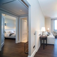 Hotel Grande Italia (I-Chioggia)  - Dalla stanza da letto al soggiorno e dal soggiorno alla stanza da letto: il pavimento in Rovere Parkemo in tinta wengè e finitura verniciata è il fil-rouge di questo ambiente elegante e contemporaneo. 