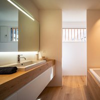 Casa sostenibile nel Canton Grigioni (CH)  - Alplus Building & Design ha scelto il legno di Parkemo anche per il rivestimento parete, vasca e lavabo. In questa foto Rovere, Collezione Versus Classic, spazzolato e oliato neutro, in formati misti.